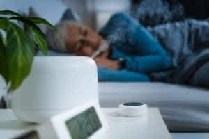stock photo of a sleeping woman using a humidifier